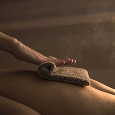 therapist-massaging-woman-s-back-with-hot-towel-spa